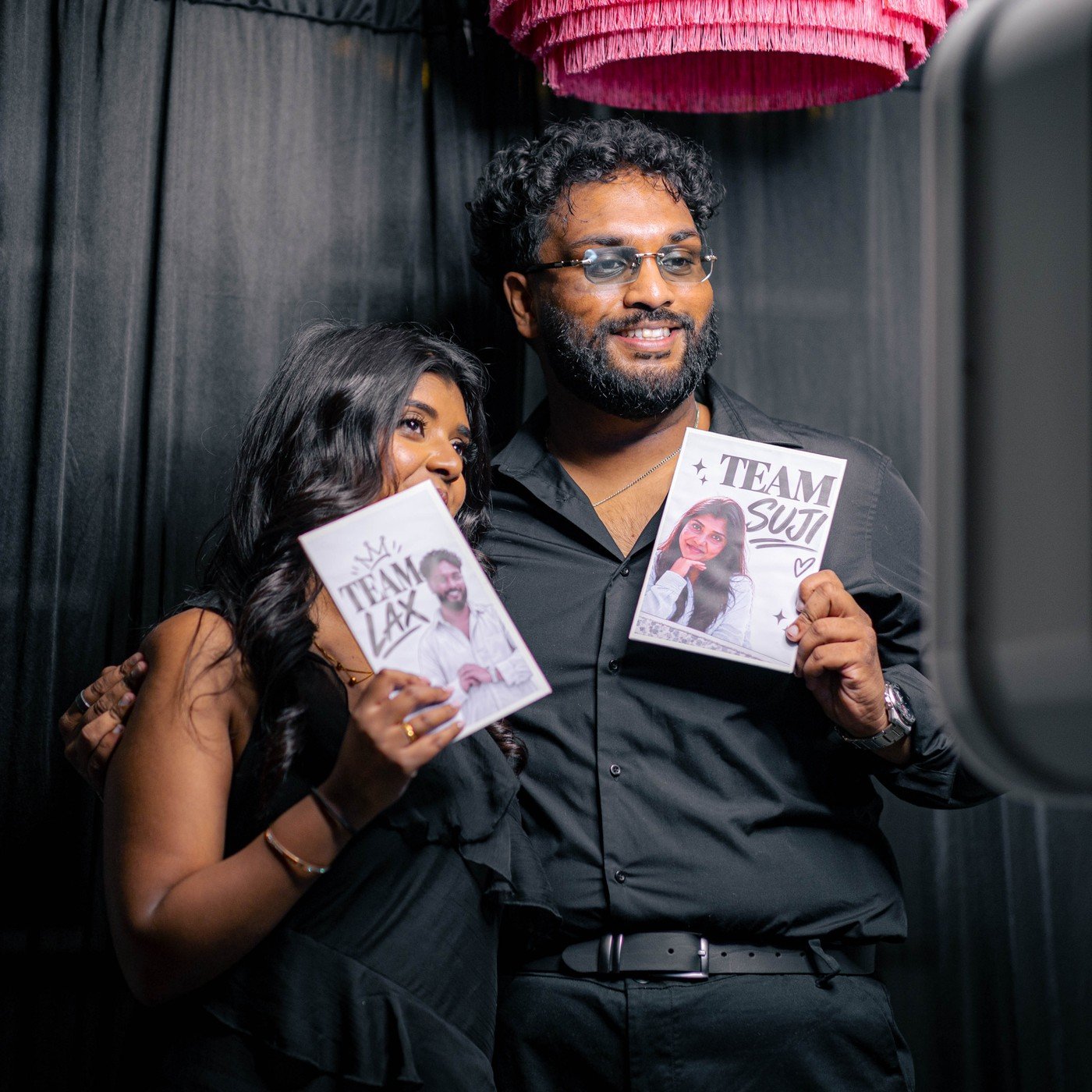 A couple holding their personalised photo booth prints together at a Manjal Events photo booth